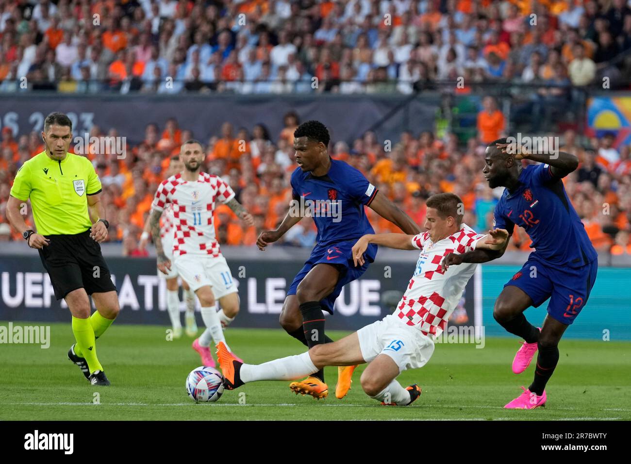 Referee Istvan Kovacs watches as Croatia's Mario Pasalic vies for the ball with Netherlands' Denzel Dumfries and' Lutsharel Geertruida, right, during the Nations League semifinal soccer match between the Netherlands and Croatia at De Kuip stadium in Rotterdam, Netherlands, Wednesday, June 14, 2023. (AP Photo/Peter Dejong) Banque D'Images
