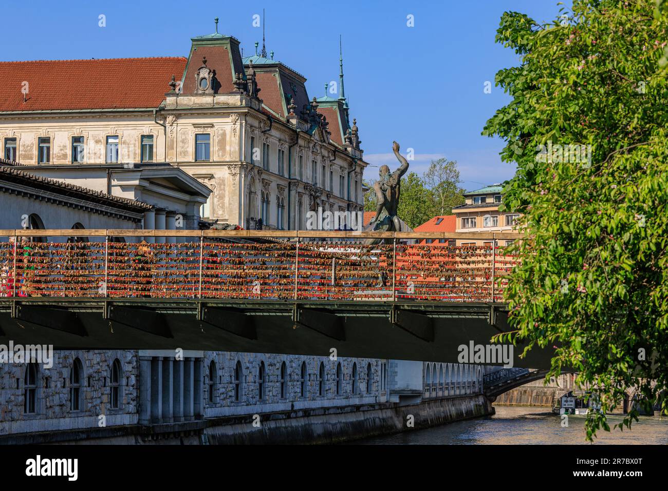 des centaines de cadenas d'amour rouge pendent sur les côtés du pont des bouchers avec ses sculptures en bronze traversant la crique de ljubljianica jusqu'au marché central Banque D'Images