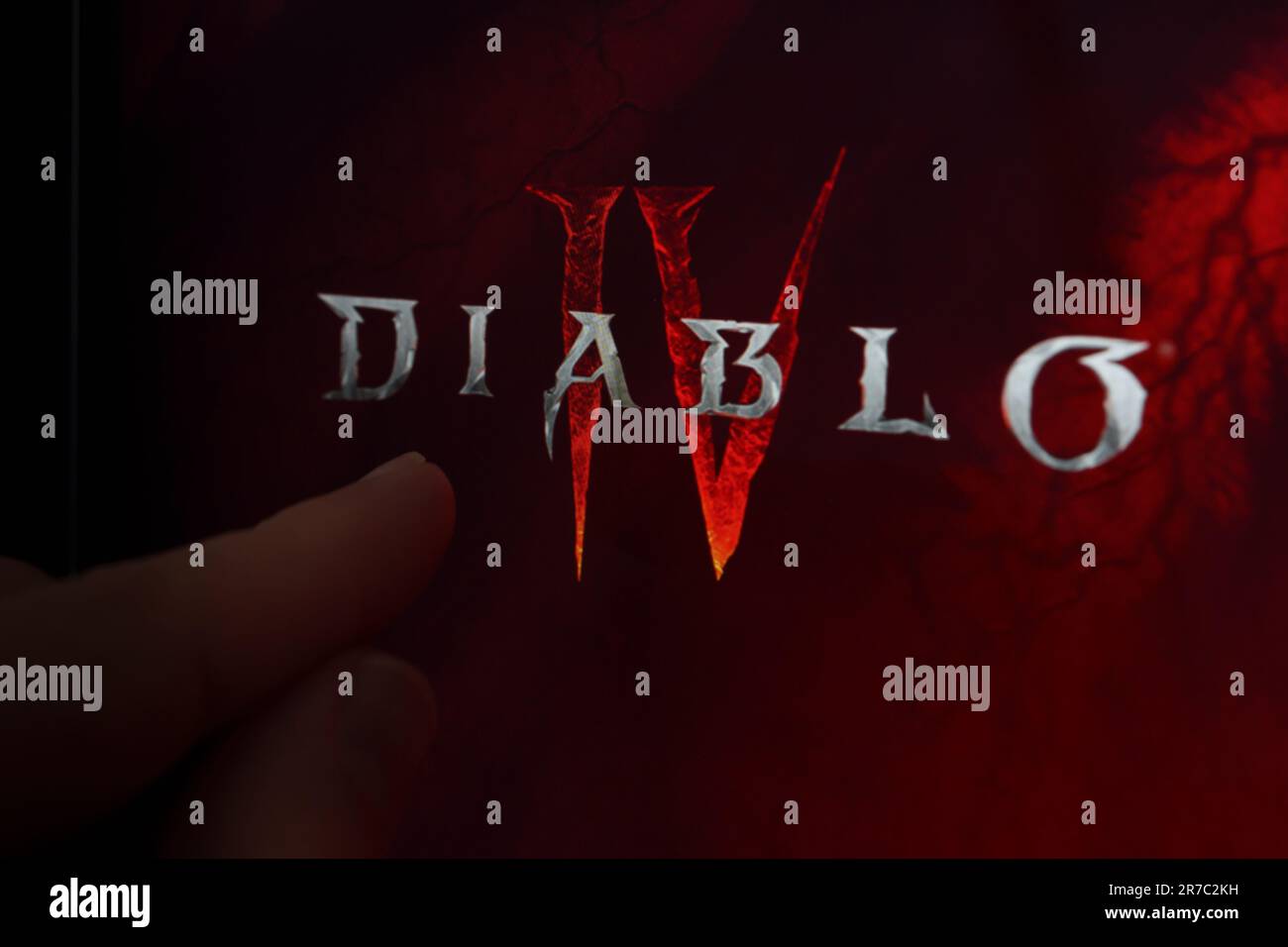 Diablo 4 logo de jeu vu sur l'écran et le doigt pointant vers lui. Diablo IV est un jeu développé par Blizzard Entertainment. Stafford, Royaume-Uni, Ju Banque D'Images