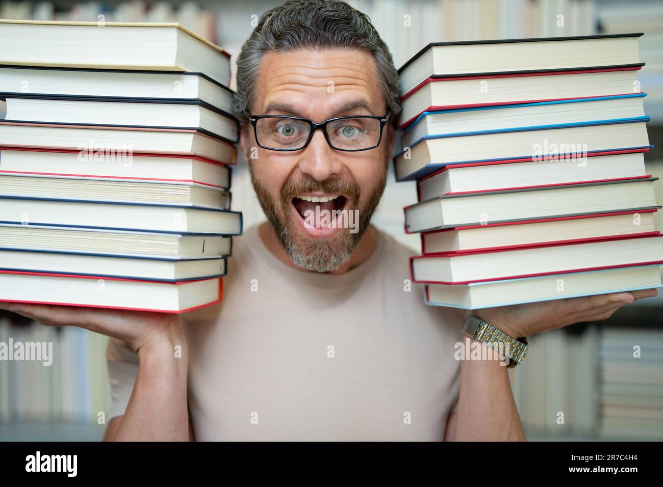Drôle d'enseignant de tenir beaucoup de livres. Professeur fou avec des livres. Enseignant enthousiaste dans la bibliothèque de livres de l'école. Examen universitaire. Étudier enseigner à l'université. Éducateur Banque D'Images