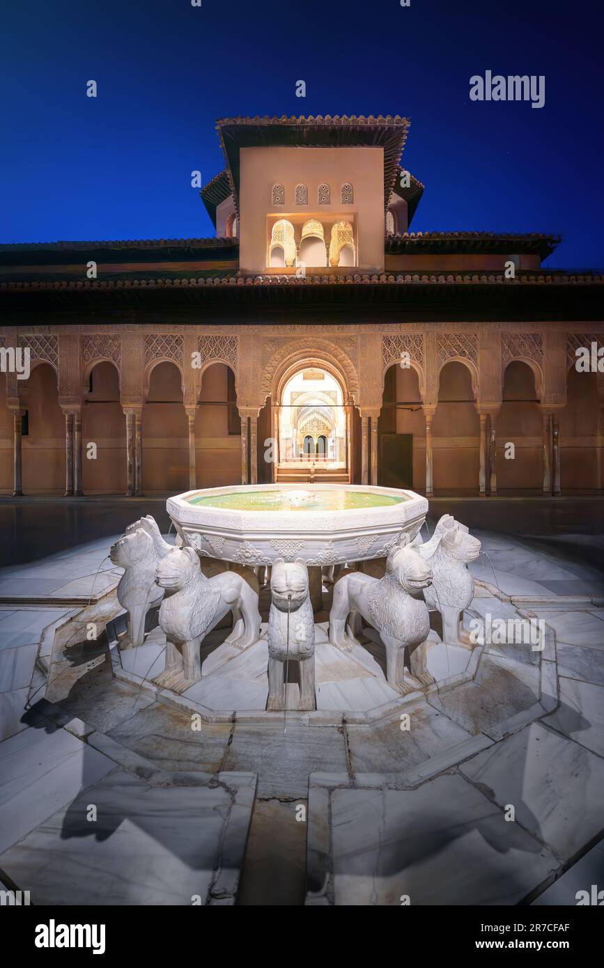 Cour illuminée des Lions (patio de los Leones) avec fontaine aux palais Nasrides de l'Alhambra la nuit - Grenade, Andalousie, Espagne Banque D'Images