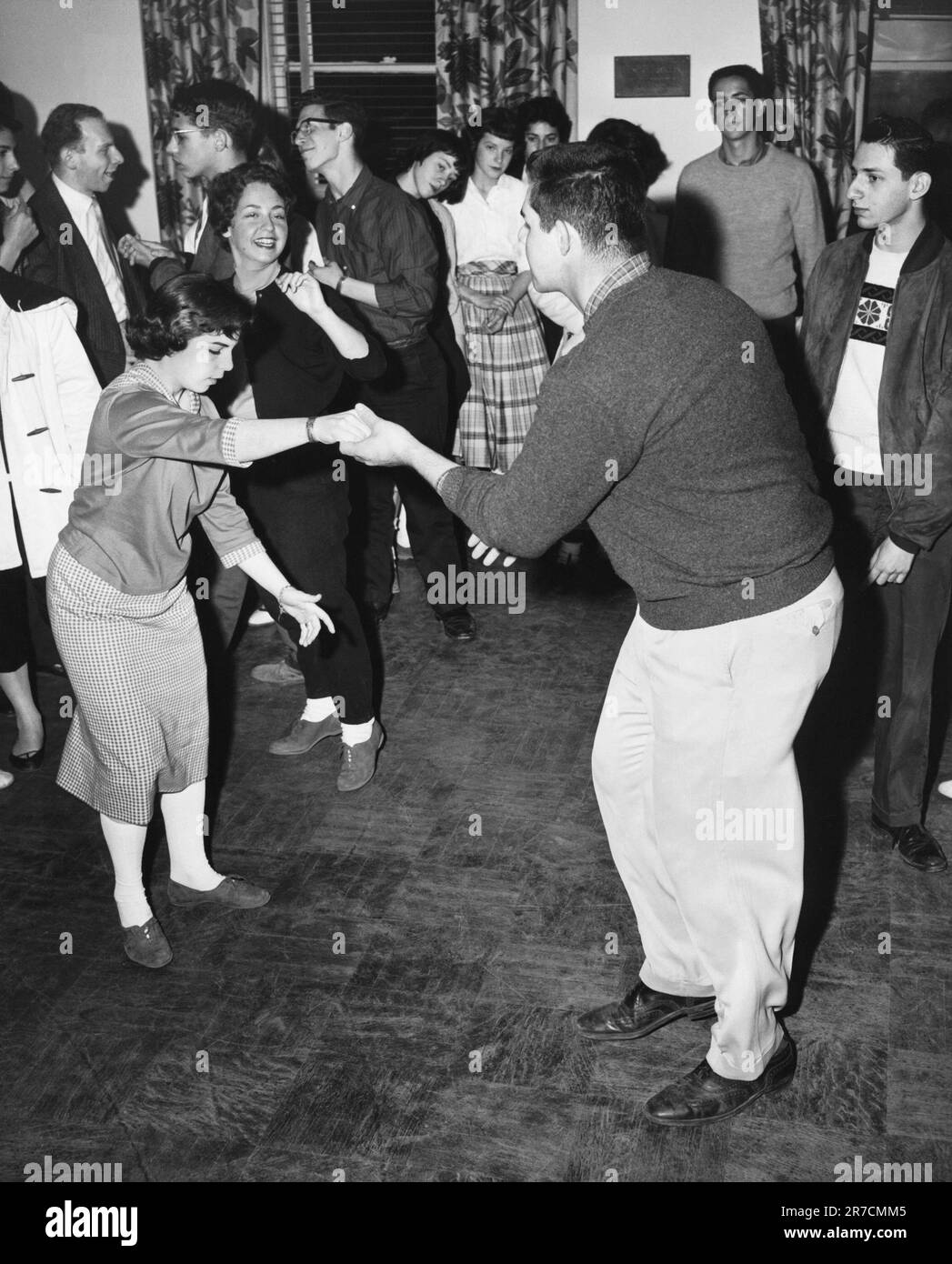 États-Unis: c. 1957 Un couple de swing dansant à une fête. Banque D'Images