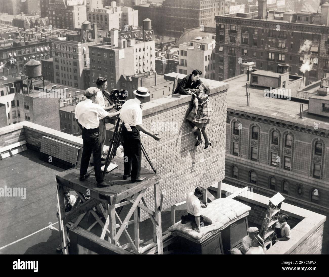 New York, New York: 1925 Une scène de cascades au sommet de l'hôtel Algonquin avec la star allene Ray accroché et Walter Miller faisant le sauvetage dans le film silencieux de Pathe Exchange, 'Play ball'. Banque D'Images