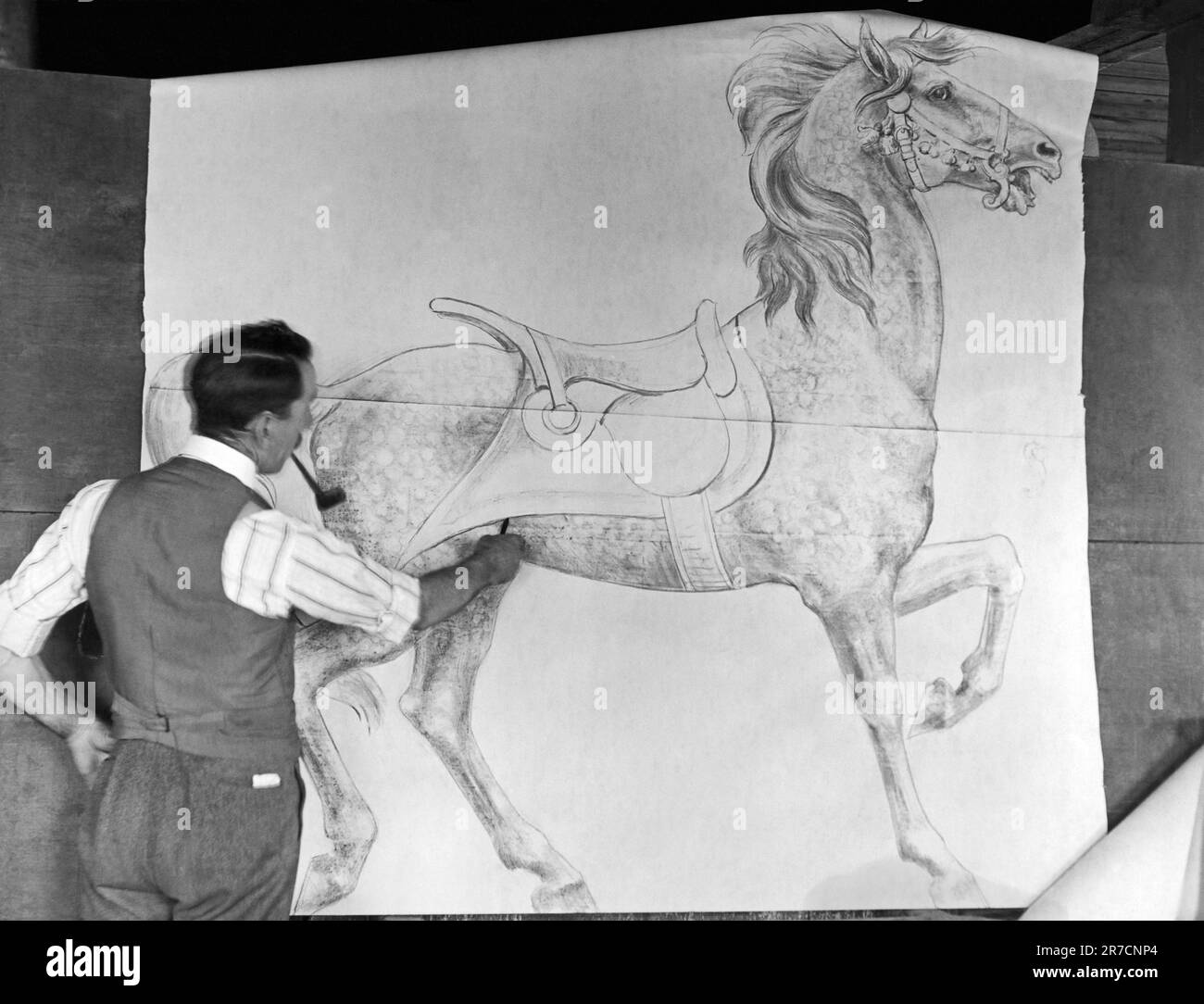 Philadelphie, Pennsylvanie : c. 1915. Le designer Daniel Muller travaille dans un atelier de carrousel d'animaux à l'usine de Dentzel dans la section Germantown de Philadelphie. Ici, il dessine une esquisse d'une figure de cheval pleine grandeur pour un carrousel. Banque D'Images