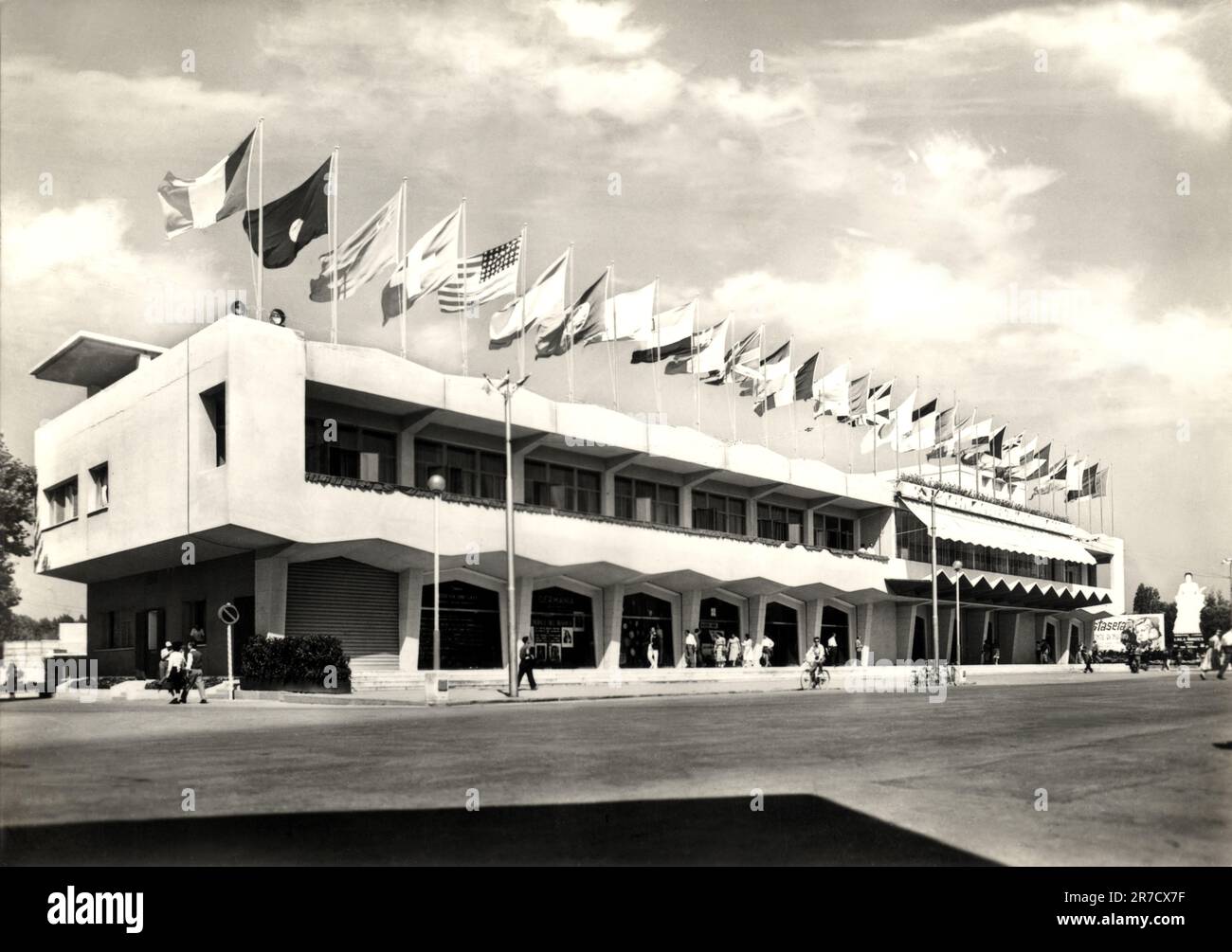 1955 , août , LIDO di VENEZIA , ITALIE : le célèbre PALAZZO DEL CINEMA pendant la Mostra internazionale d'arte cinematografica di Venezia ( Espossizione Internazionale d'Arte Cinematografica - Biennale di Venezia ). Ouvert le 10 août 1937 pour l'édition V du film Festival , conçu dans un style RATIONALISTE par l'architecte LUIGI QUAGLIATA ( 1899 - 1991 ). Photographe inconnu .- FESTIVAL DU CINÉMA - CINEMATOGRAFICO - ITALIA - ARCHITETURA RAZIONALISTA - ARCHITECTURE RATIONALISTE - VENISE - drapeau - bandiera - drapeaux des nations - bandiere nazionali -TURISMO - TOURISME - turisti - touriste - Banque D'Images