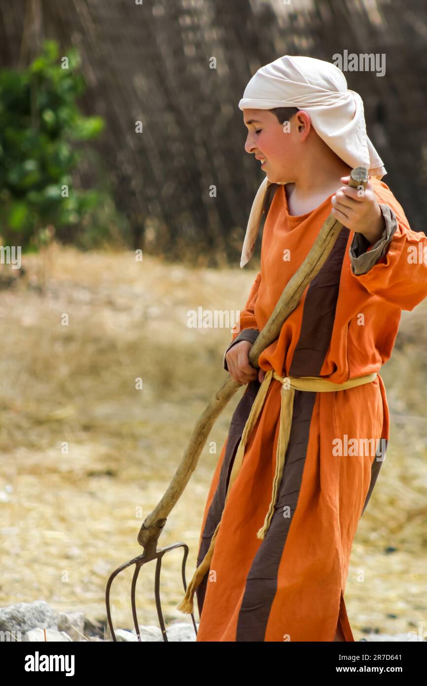Un jeune acteur dépeint un garçon de ferme du premier siècle au musée en plein air du village de Nazareth, en Israël. Banque D'Images