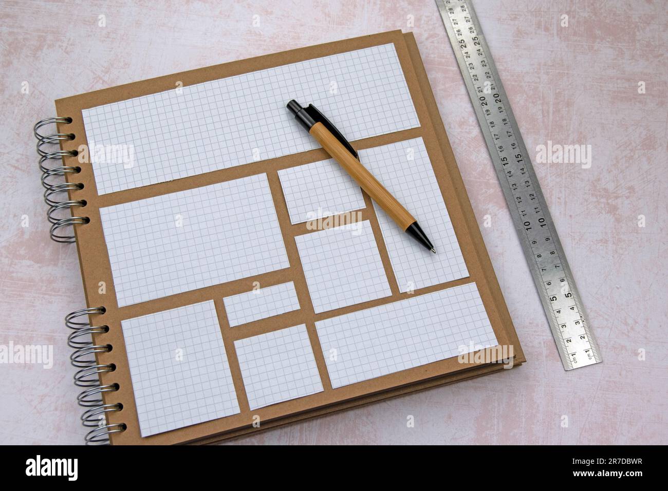 Découpes de papier à lignes carrées sur le scrapbook à anneaux. Stylo en bambou à règle métallique. Copier l'espace Banque D'Images