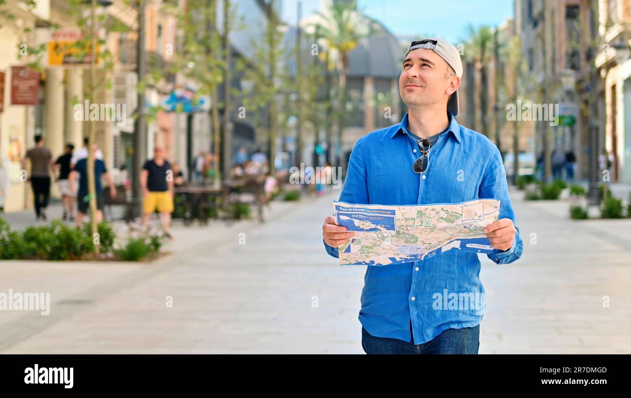 Homme explorant la ville avec une carte dans ses mains à Alicante, Espagne Banque D'Images