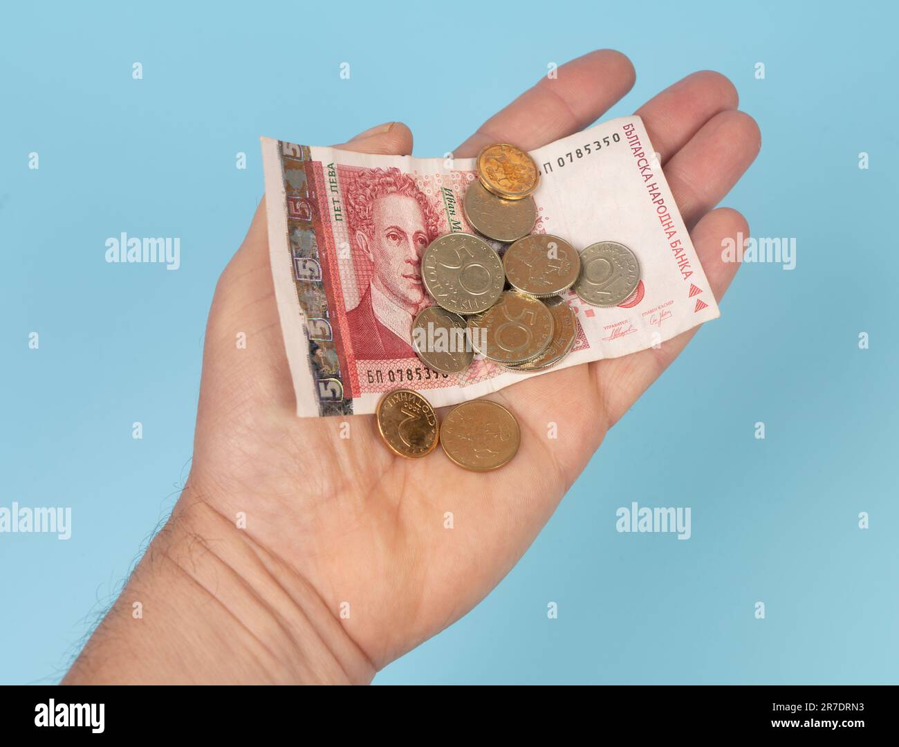 Un billet de banque et quelques pièces de Lev monnaie dans la paume d'une main Banque D'Images
