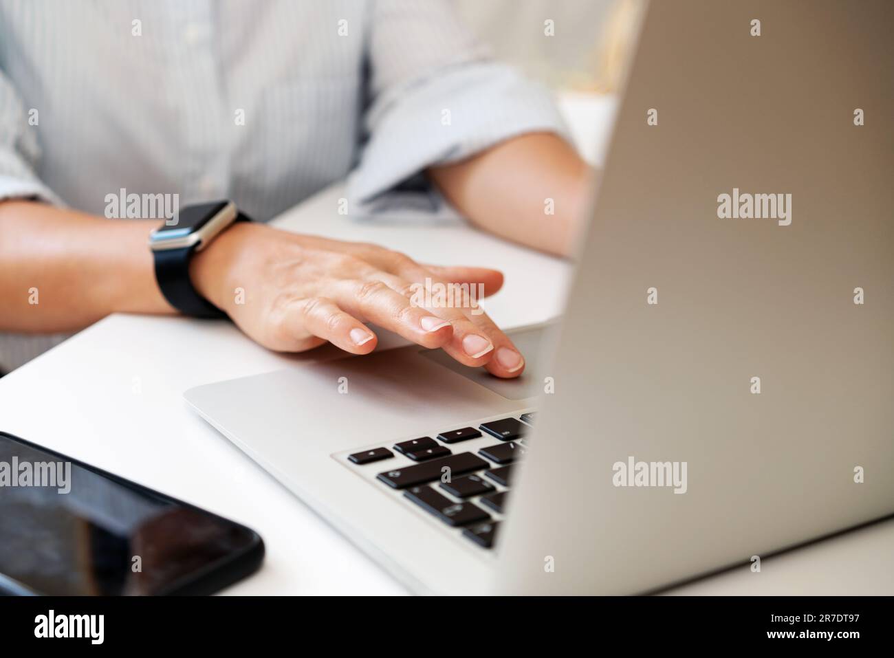 Gros plan photo des doigts de femmes sur le pavé tactile de l'ordinateur portable, femme d'affaires utilisant son ordinateur portable dans le bureau. Banque D'Images