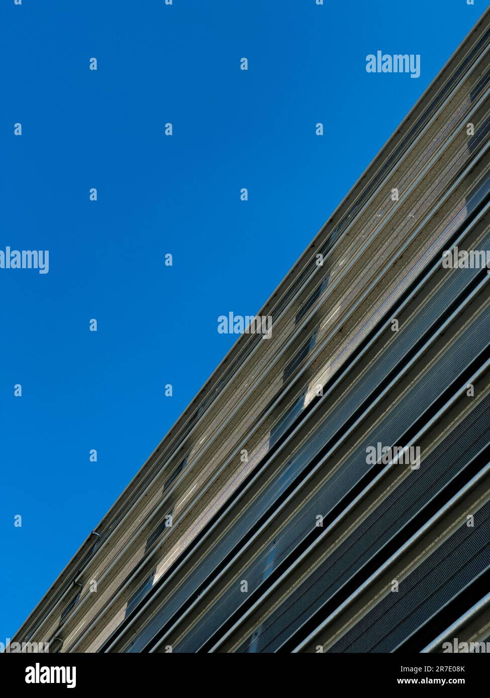 Façade extérieure contemporaine d'un parking à plusieurs étages, vue depuis le sol vers un ciel bleu sans nuages. ROYAUME-UNI Banque D'Images
