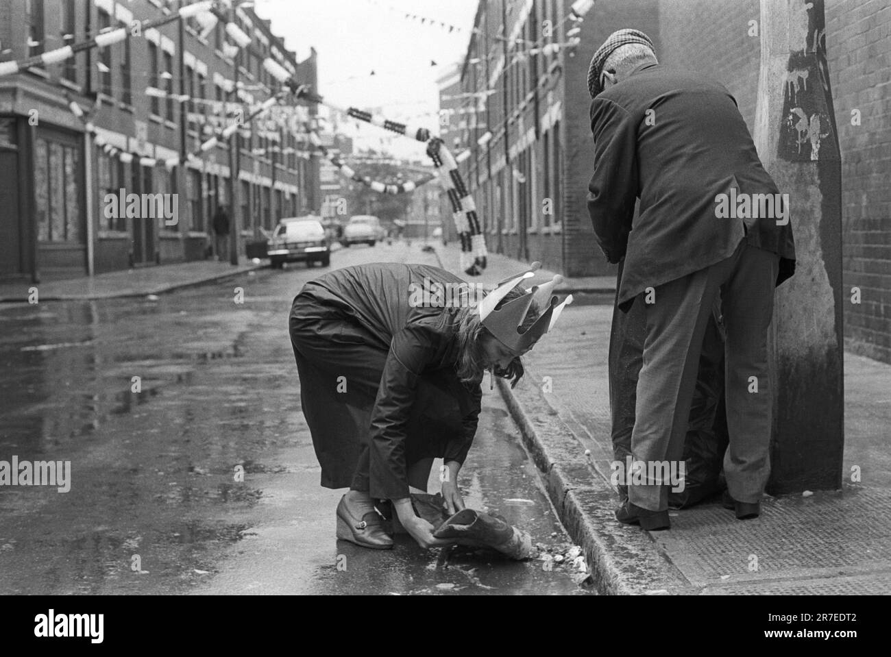 Reine Elizabeth II célébration du Jubilé d'argent 1977. Repton Street, la fête de la rue est terminée et deux locaux ramassent la portée. Whitechapel, Tower Hamlets, est de Londres, Angleterre vers juin 1977. Banque D'Images