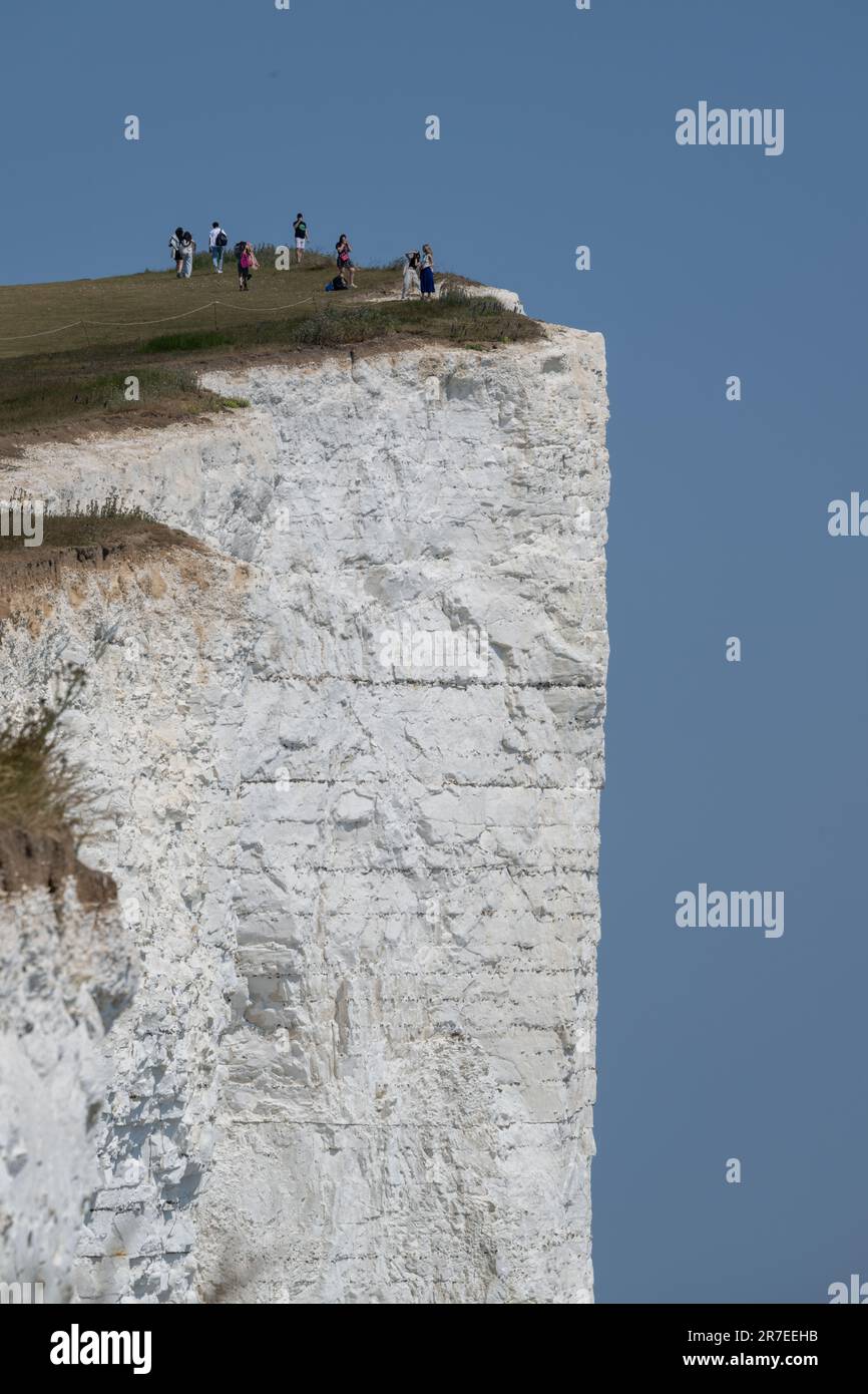 Touristes se tenant dangereusement près de Beachy Head Cliff Edge, Burning Gap, East Sussex. Ces dangereuses falaises de craie s'effondrent régulièrement Banque D'Images