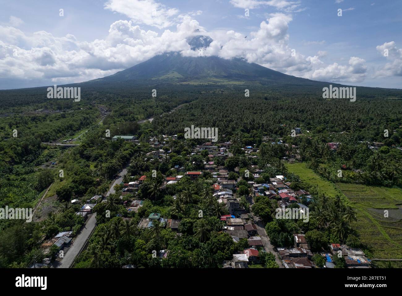 Houses near Mayon volcano as it continues to spew hot emissions as seen from Legazpi city, Albay province, northeastern Philippines, Thursday, June 15, 2023. Thousands of residents have left the mostly poor farming communities within a 6-kilometer (3.7-mile) radius of Mayon's crater in forced evacuations since volcanic activity spiked last week. (AP Photo/Aaron Favila) Banque D'Images