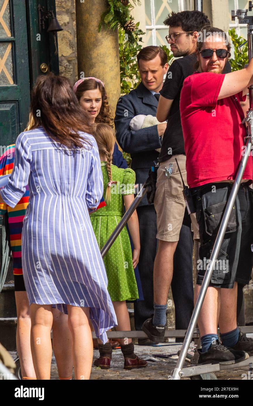 Grassington, Yorkshire Dales, Royaume-Uni 14th juin 2023. Les acteurs et l'équipage du populaire Channel 5 et PBS re-make de toutes les créatures Great et Small ont été en vigueur tournage pour la série 4 spécial Noël. Nicolas Ralph (James Herriot) est vu tenir un bébé nouveau-né à côté de son épouse à l'écran Rachel Shenton (Helen Herriot) tout en se préparant à filmer une scène à l'extérieur de la maison de Skeldale. Credit: Tom Holmes / Alamy Live News Banque D'Images