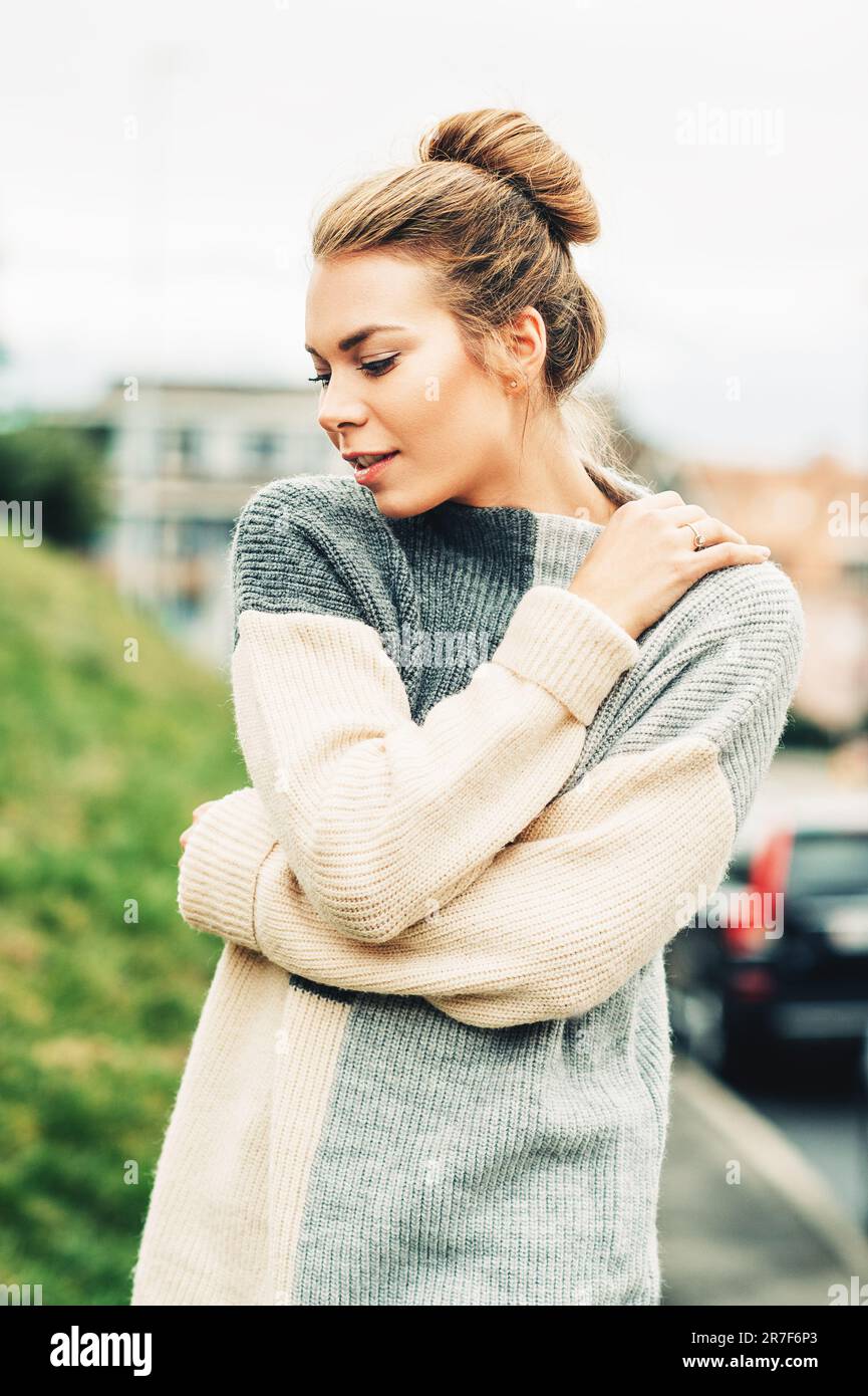 Portrait d'extérieur de la jeune jolie femme portant un pull gris chaud à col haut, temps froid Banque D'Images