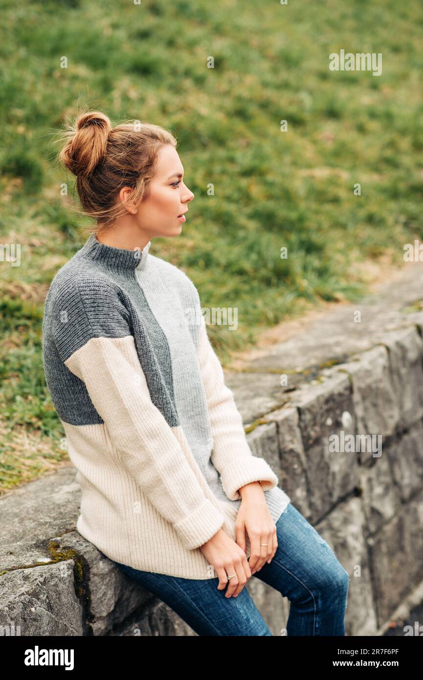 Portrait d'extérieur de la jeune jolie femme portant un pull gris chaud à col haut, temps froid Banque D'Images