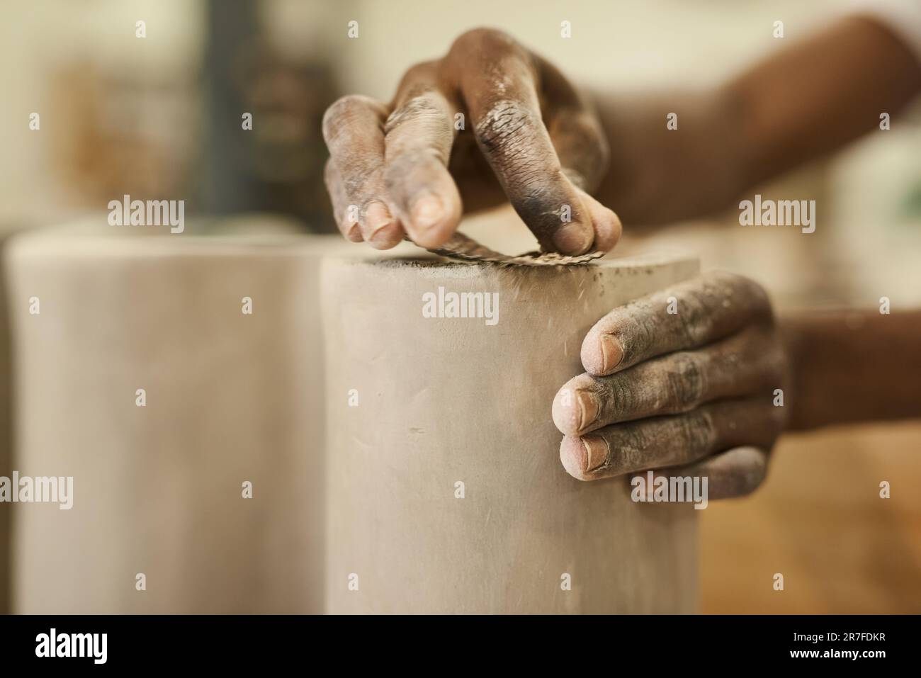 Céramiste africain ponçant un pot d'argile dans un banc de poterie Banque D'Images