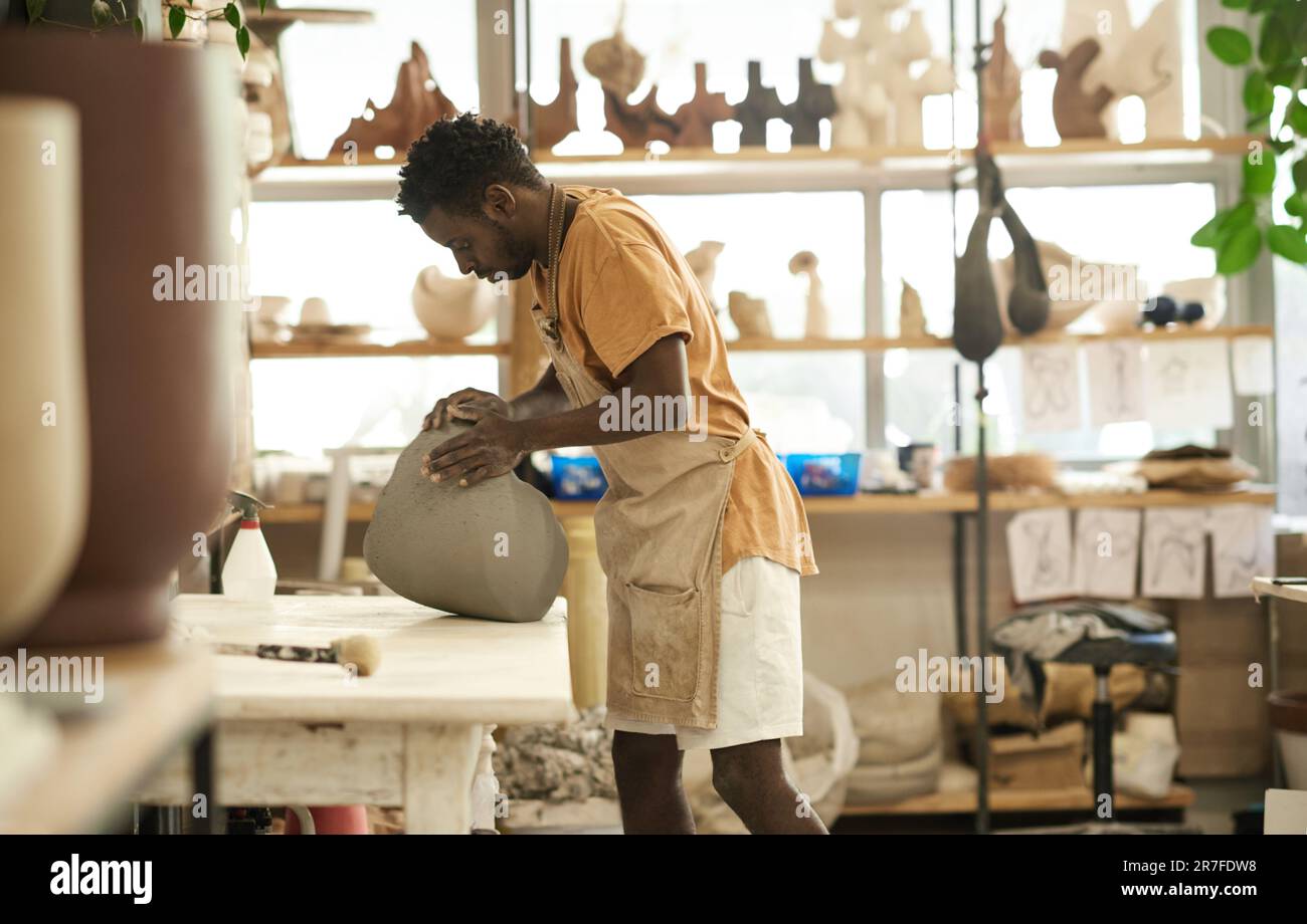 Céramiste africain façonnant un morceau d'argile dans un atelier de poterie Banque D'Images