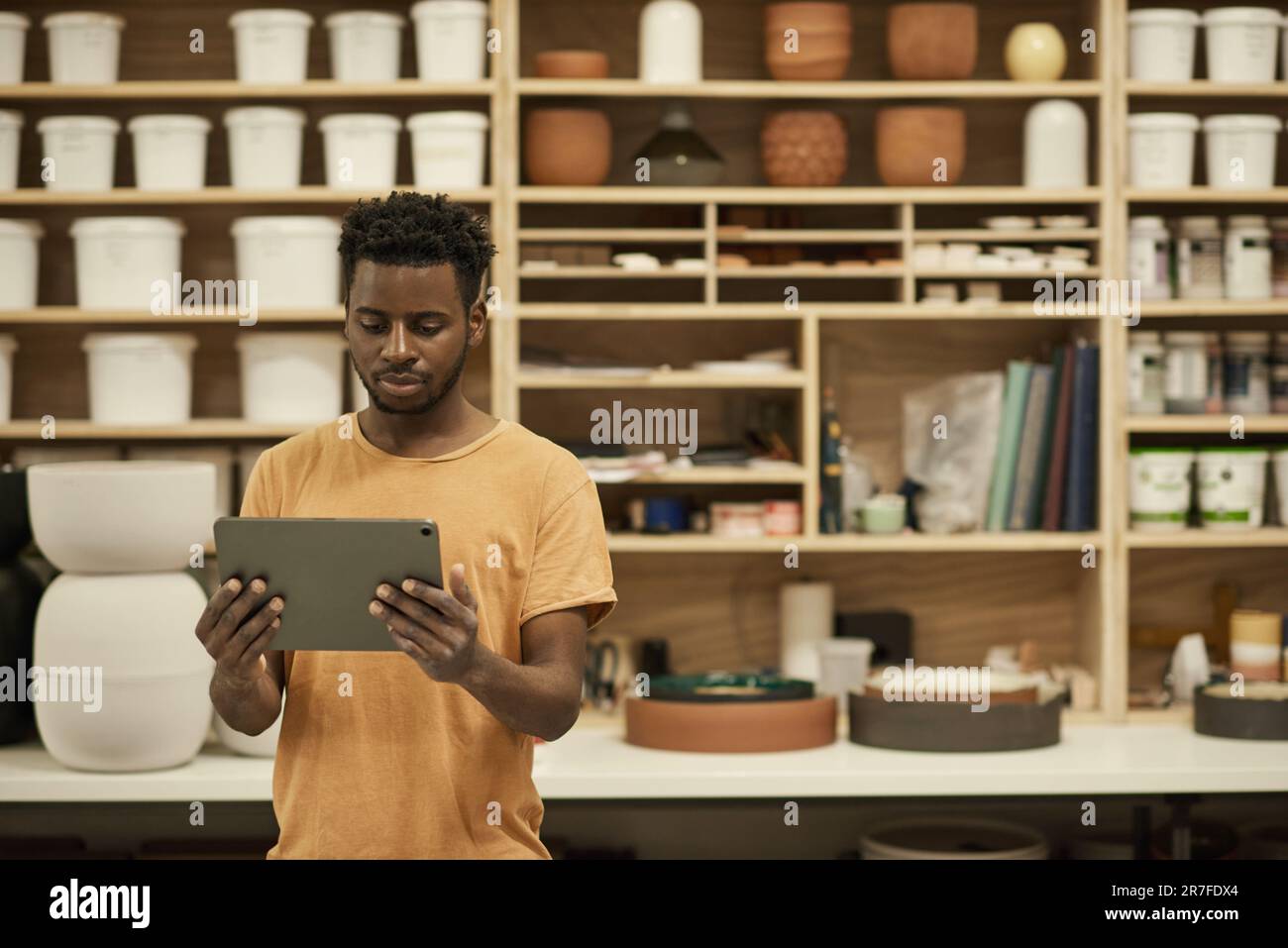 Directeur de studio céramique africain travaillant sur une tablette numérique Banque D'Images