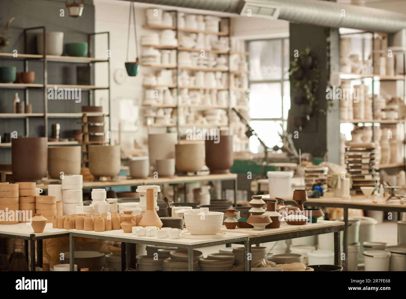 Pots d'argile assis sur des étagères et des tables dans un atelier de céramique Banque D'Images
