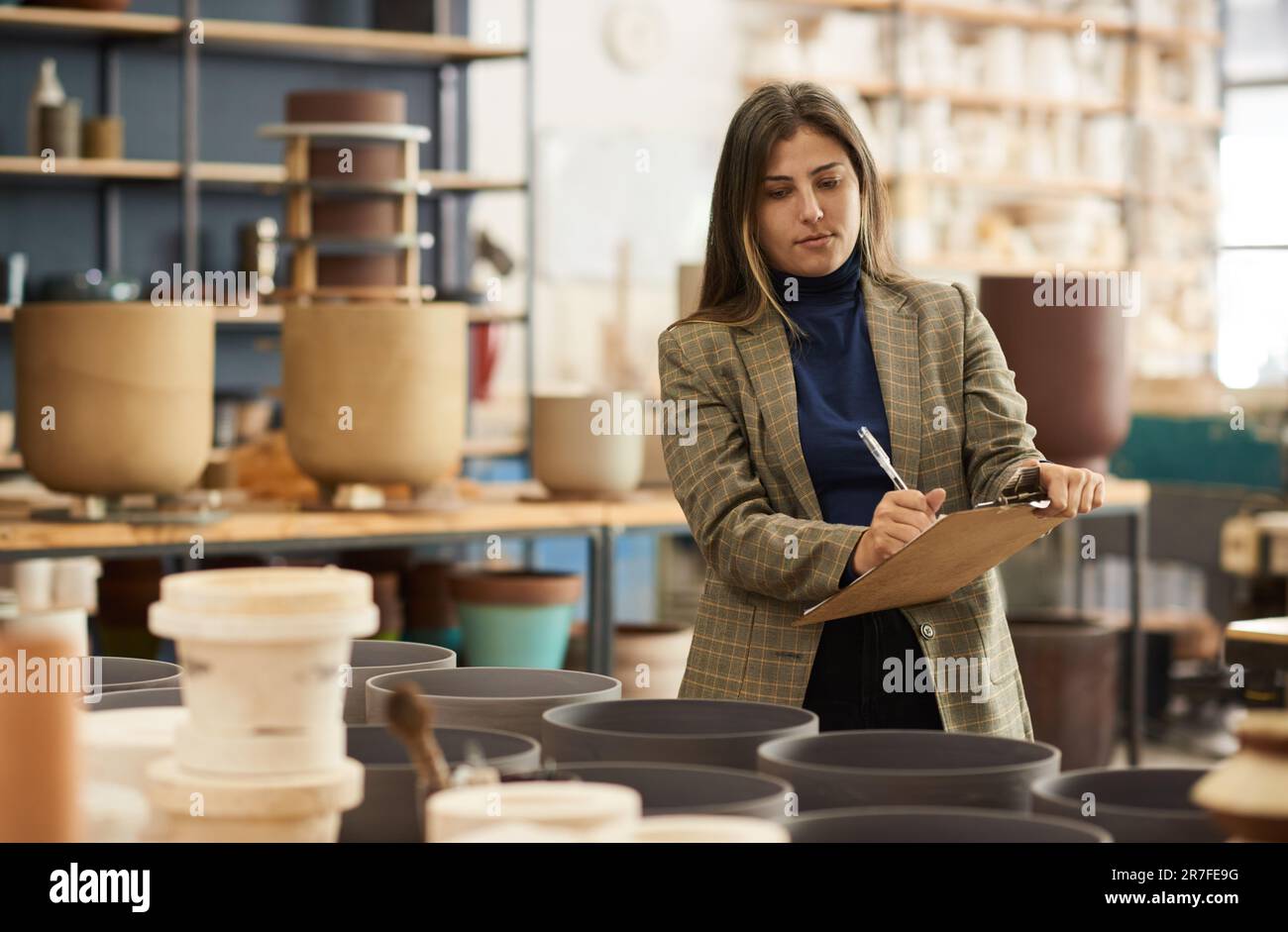 Propriétaire de l'atelier de céramique prenant l'inventaire dans un studio de poterie Banque D'Images