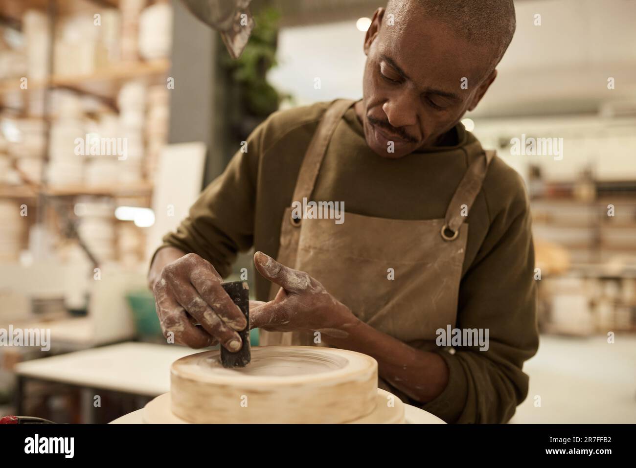 Céramiste africain travaillant à une roue de poterie dans un studio Banque D'Images