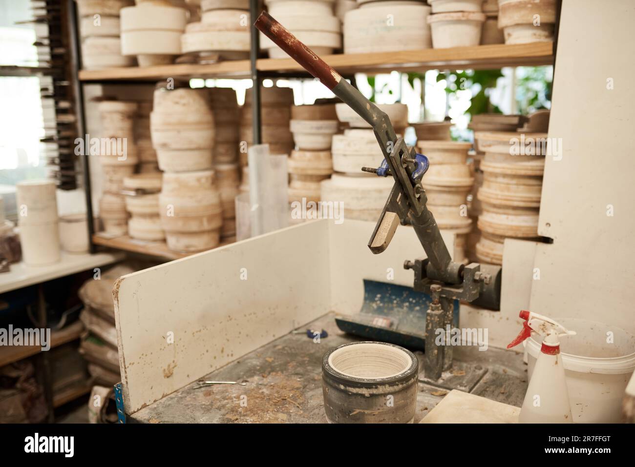 Moule assis sur un banc dans un grand atelier de fabrication de poterie Banque D'Images