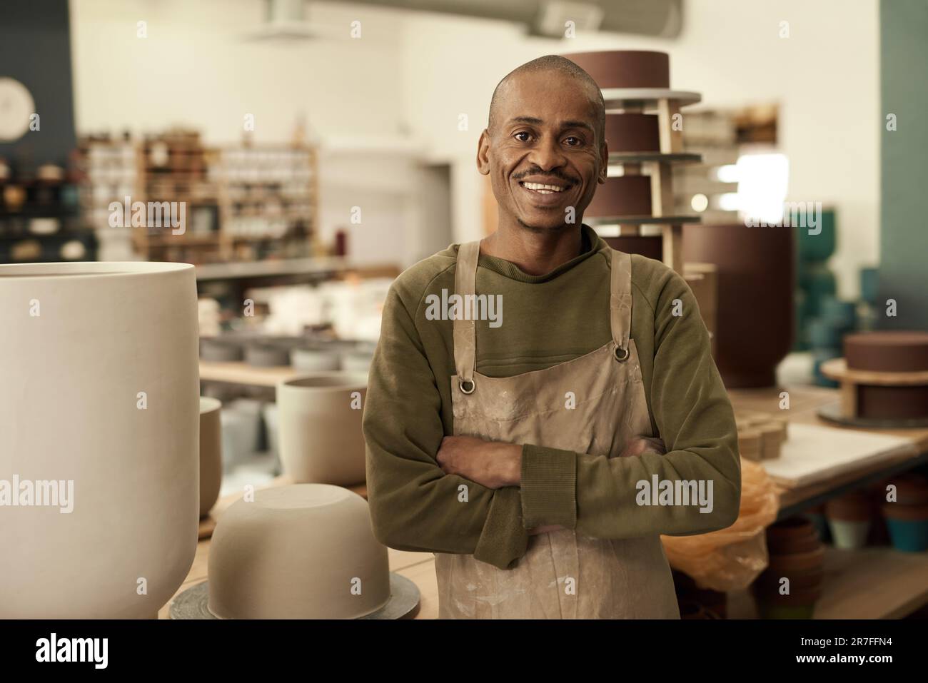 African potter souriant en se tenant dans un atelier de poterie Banque D'Images