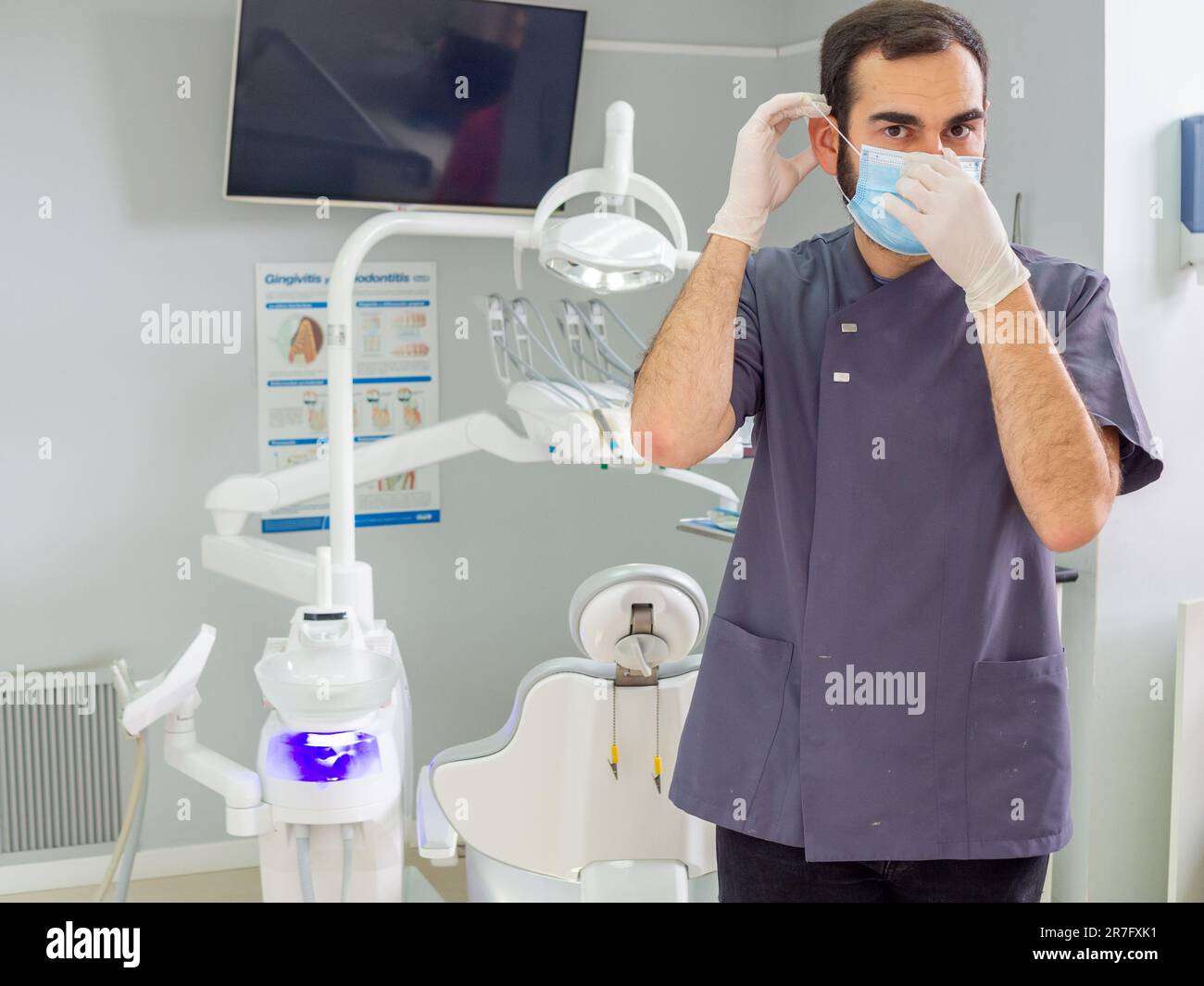 Un jeune dentiste a utilisé un masque et des gants dans une clinique lors d'un examen clinique Banque D'Images