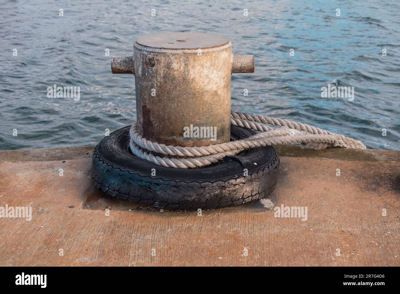 Photographie d'une corde blanche enroulée autour d'un bateau en acier amarant un bollard sur King Island, dans le détroit de Bass en Tasmanie, en Australie Banque D'Images