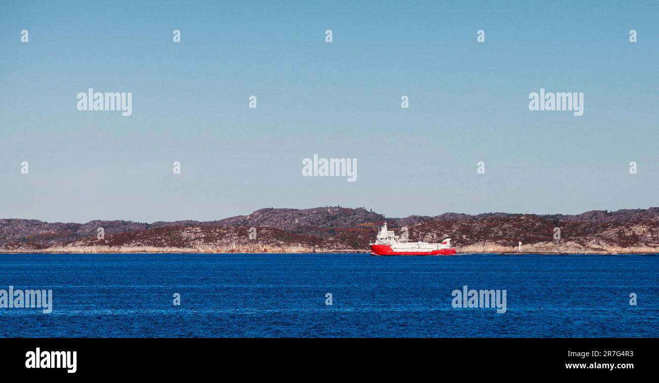 Bateau porte-poisson à coque rouge navigue la mer de Norvège par une journée ensoleillée, photo panoramique Banque D'Images