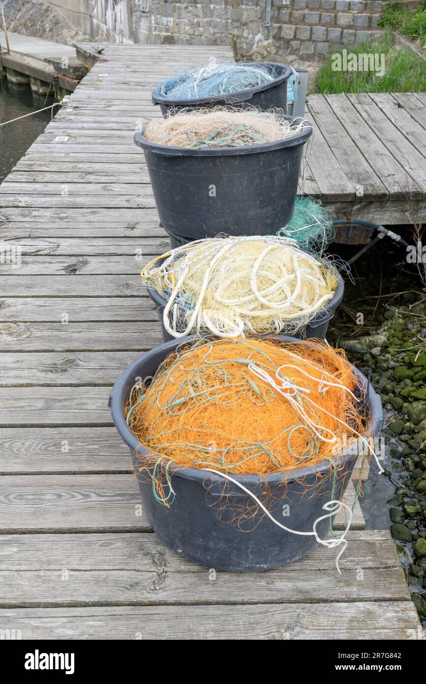 Jetée au port avec seaux et divers filets de pêche Banque D'Images