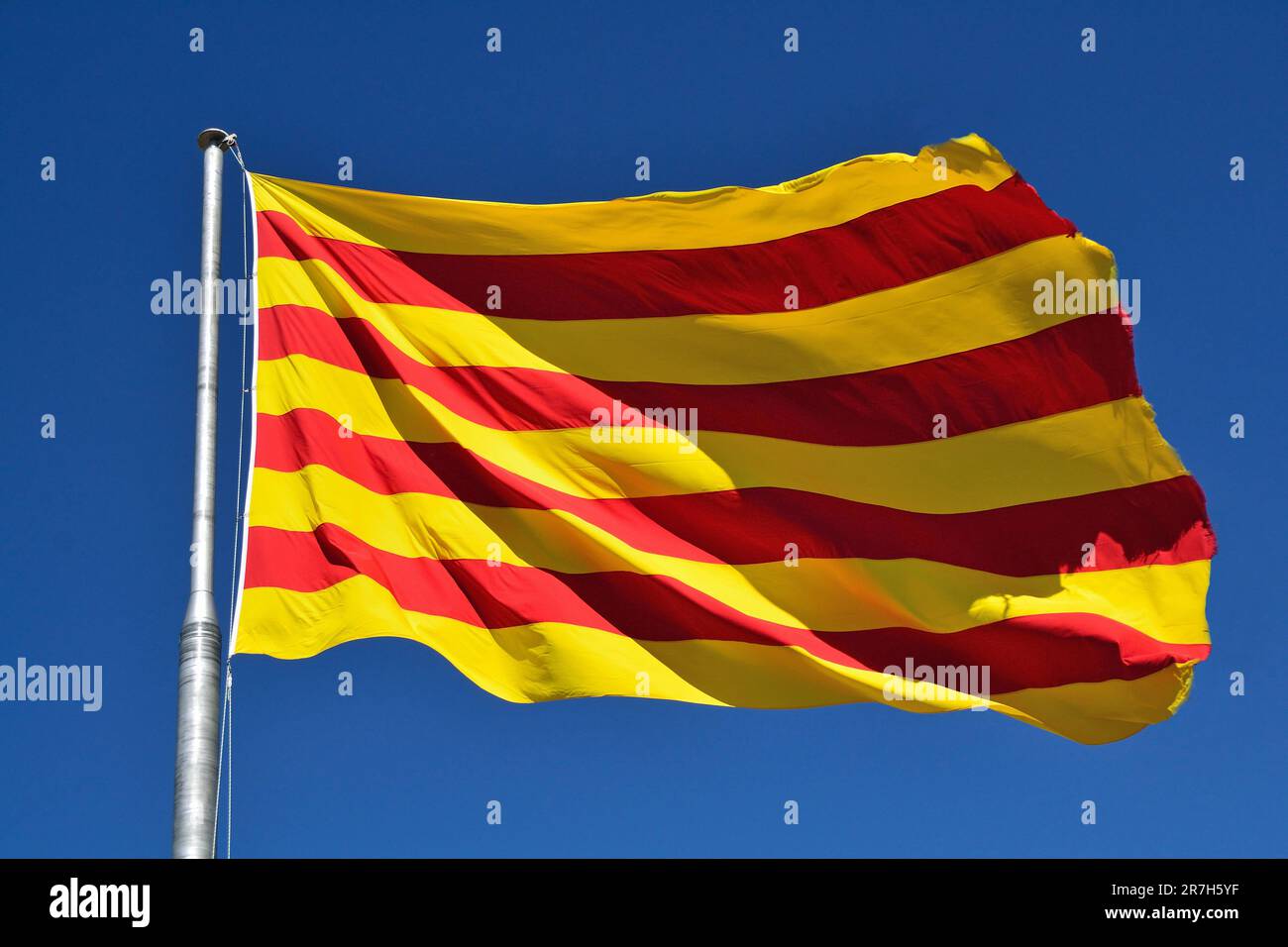 Drapeau de la Catalogne agitant dans le vent. Avec fond bleu ciel Banque D'Images