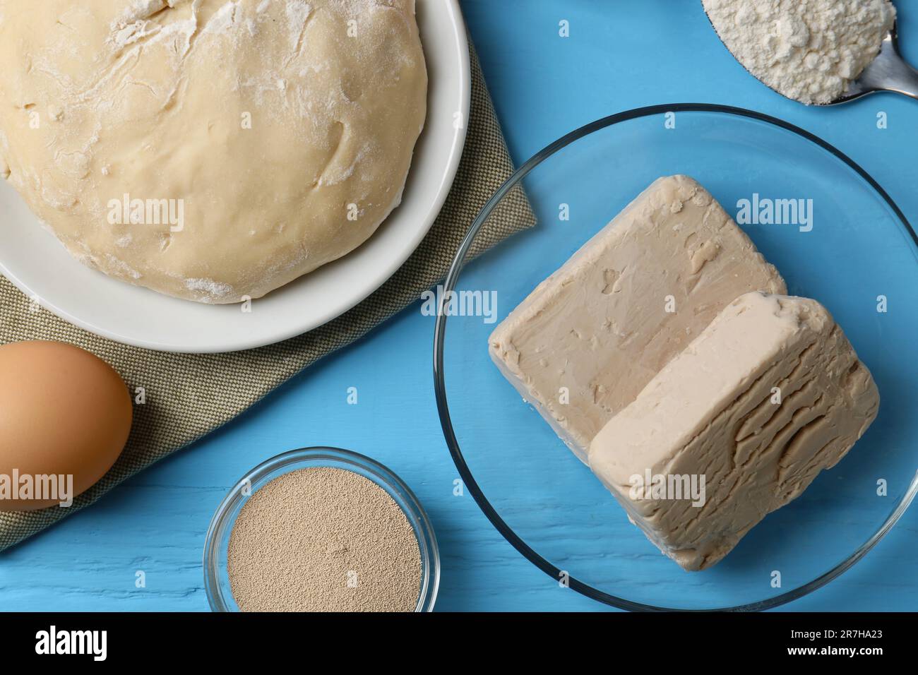 Différents types de levure, oeufs, pâte et farine sur table en bois