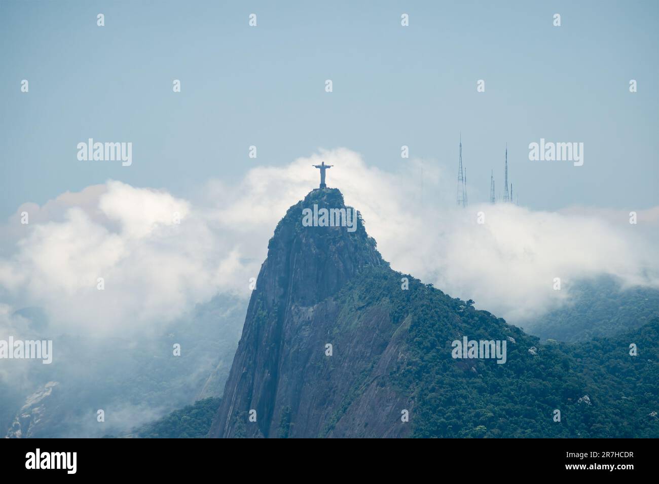 Vue lointaine de la montagne du Corcovado (hunchback), maison de la statue du Christ Rédempteur telle que vue de la montagne de Sugarloaf sous ciel bleu ciel nuageux d'été. Banque D'Images