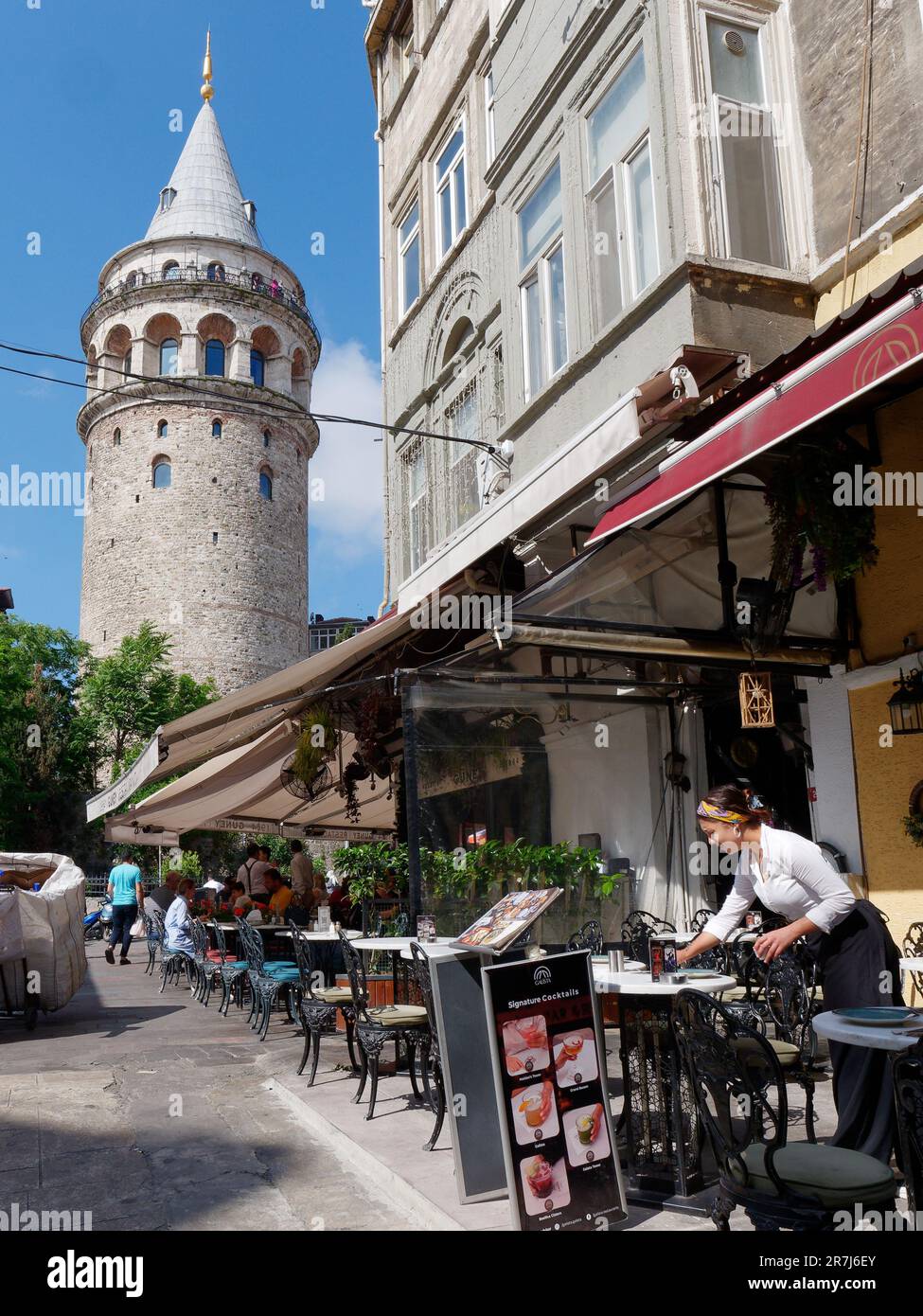 Le serveur pose une table de restaurant devant la Tour de Galata, quartier de Galata, Istanbul, Turquie Banque D'Images