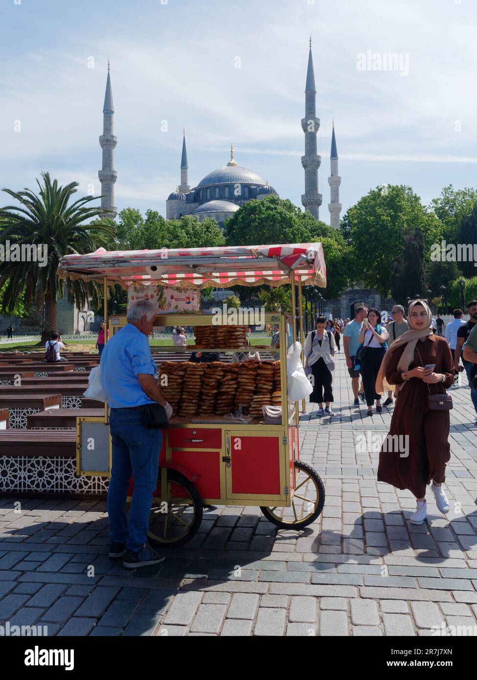 Chariot rouge avec des Simits turcs aka bagels turcs avec la mosquée Sultan Ahmed (aka Mosquée bleue) derrière. Istanbul, Turquie. Banque D'Images
