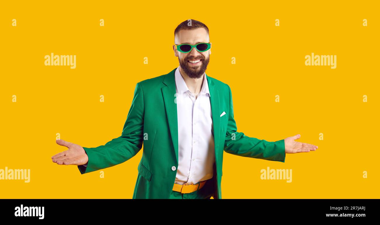 Drôle d'homme heureux en costume vert et lunettes de soleil vous accueillant à la fête de la St Patrick Banque D'Images