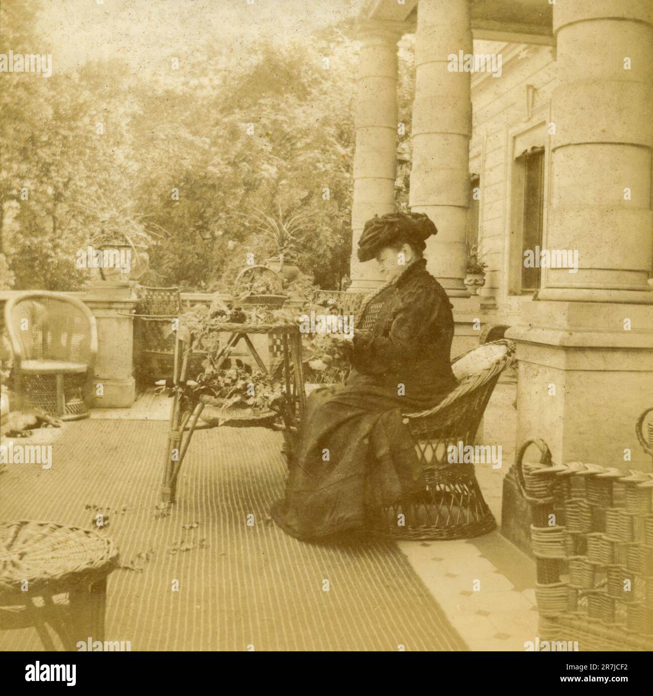 Grande femme portant une longue robe noire faisant des couronnes de fleurs, Italie 1910s Banque D'Images