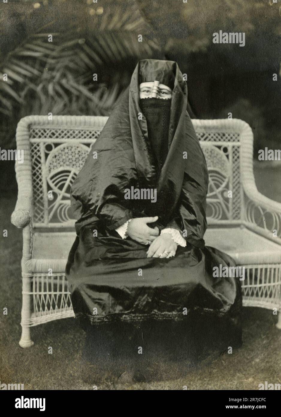 Femme portant une tenue arabe noire assise dans le jardin, Italie 1920s Banque D'Images