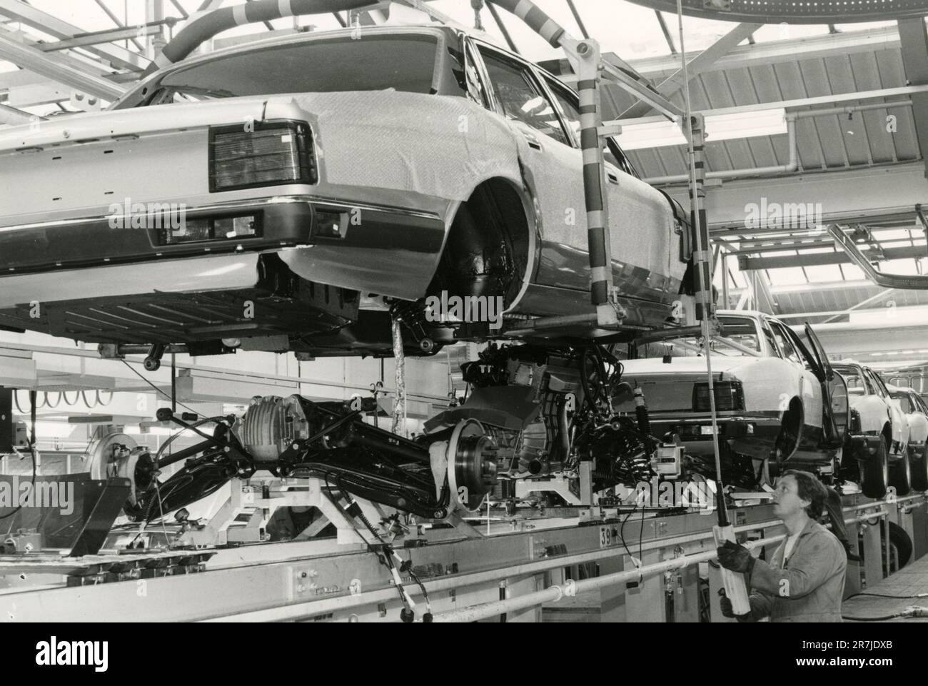 XJ40 benne abaissée sur le moteur et suspension dans l'usine automobile Jaguar de Browns Lane, Royaume-Uni 1986 Banque D'Images