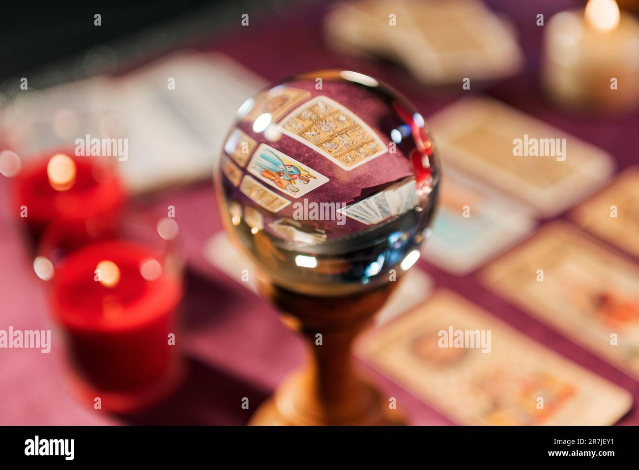 Mise au point sélective de verre boule de cristal près des cartes de tarot et de bougies de combustion sur la table contre un arrière-plan flou pour prédire l'avenir Banque D'Images