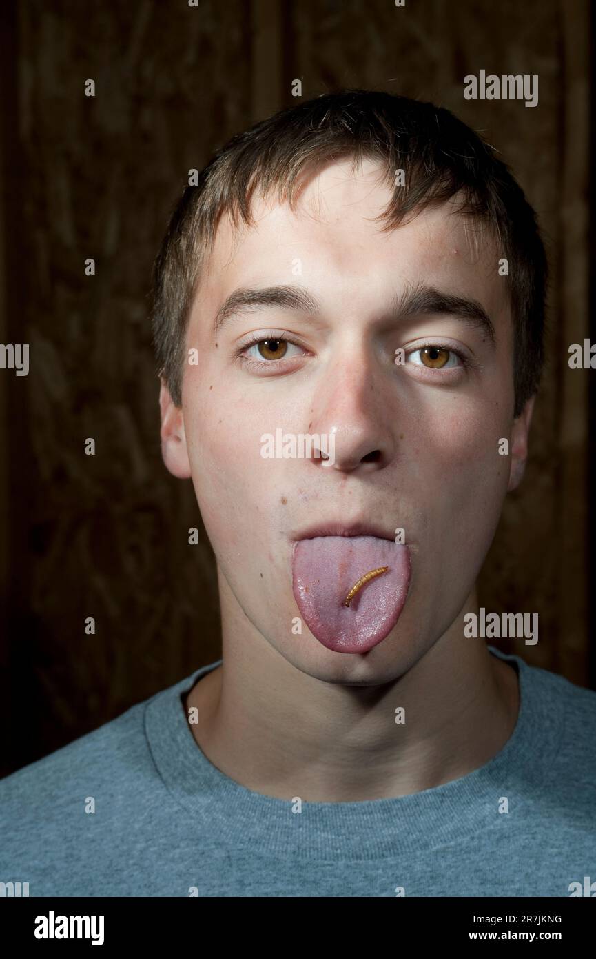 Un garçon de quatorze ans colle sa langue pour montrer un magot qu'il est sur le point de manger pendant un Banque D'Images