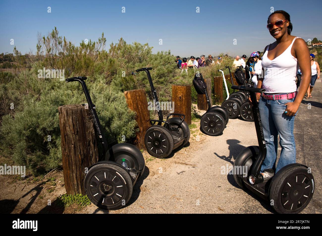 Une jeune femme noire sourit sur son Segway. Banque D'Images Une jeune femme noire sourit sur son Segway. Banque D'Images