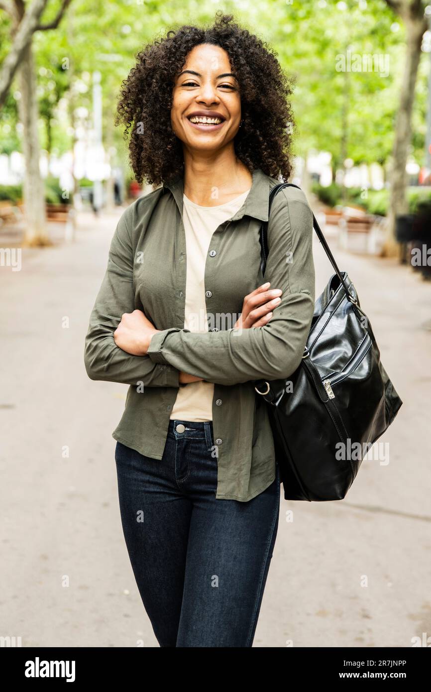 Joyeuse belle femme souriante regardant la caméra avec les bras croisés. Banque D'Images