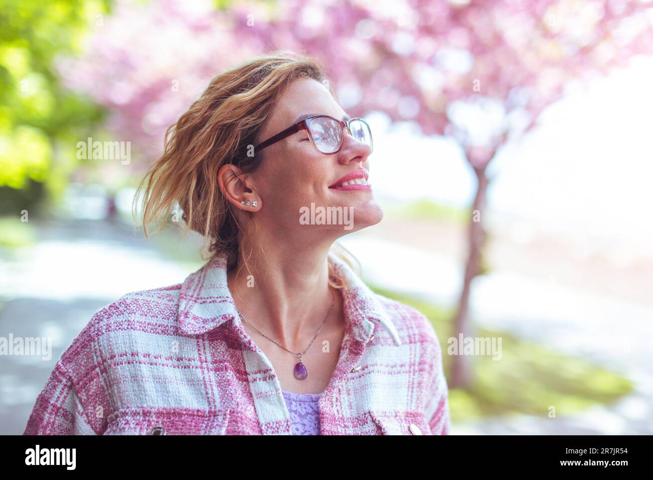 Femme de race blanche, insouciante, en train de marcher pendant le printemps dans le parc Banque D'Images