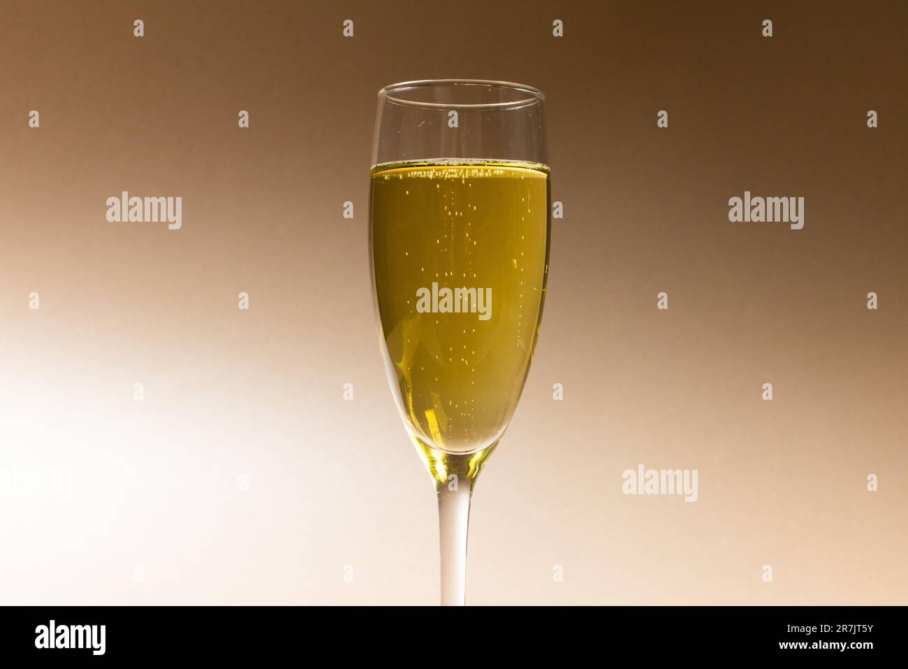 Gros plan de champagne en flûte à champagne isolé sur fond brun, espace copie Banque D'Images