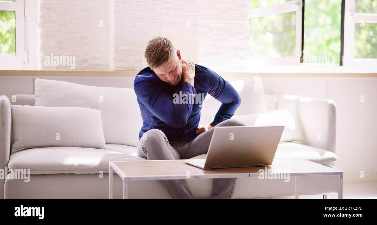 Homme travaillant sur ordinateur portable avec blessure au cou douleur et inflammation Banque D'Images