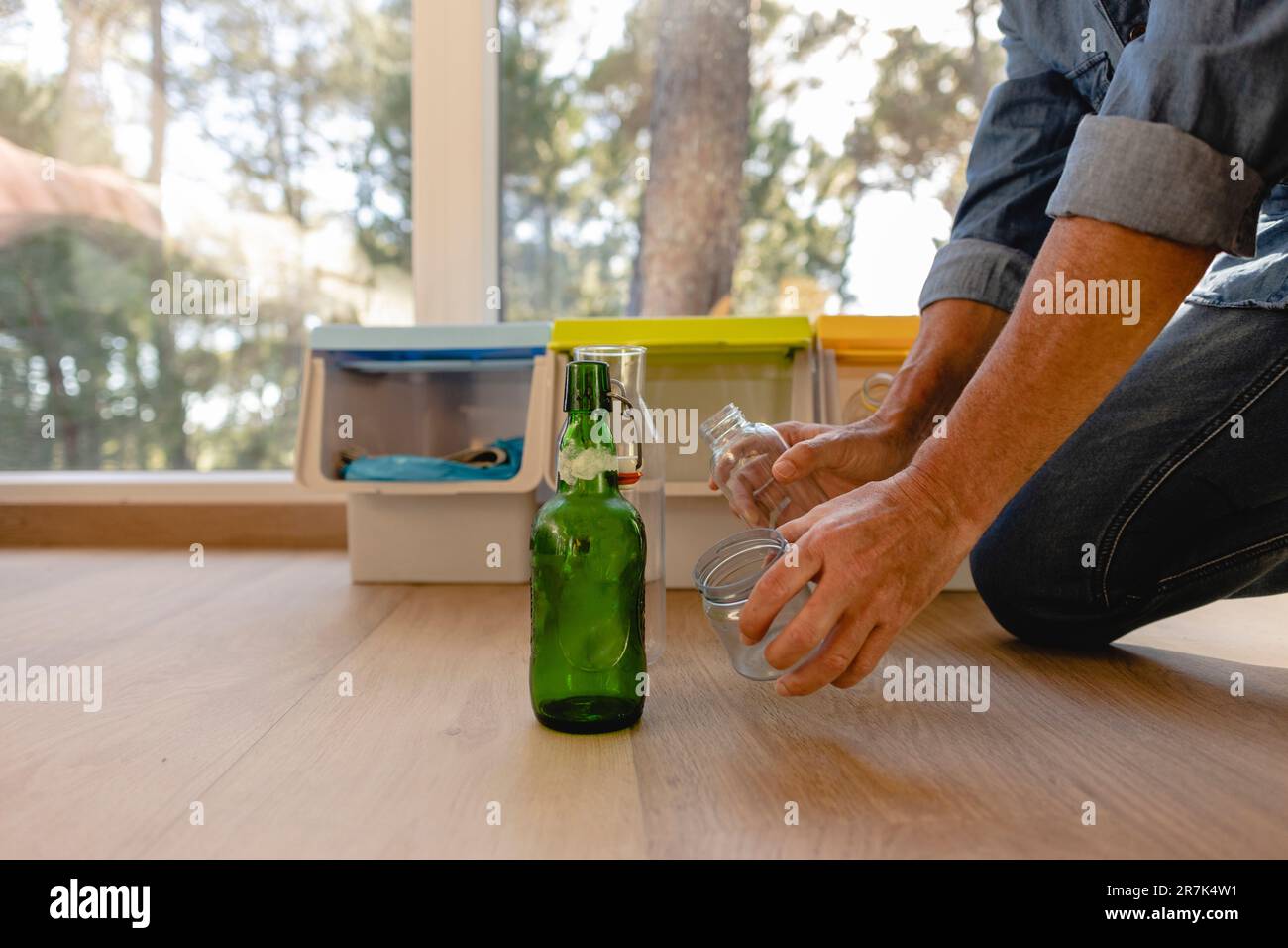 Homme triant les déchets dans le bac de séparation des déchets Banque D'Images